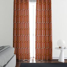 a living room with a couch, chair and window covered in orange curtain panels next to a white coffee table