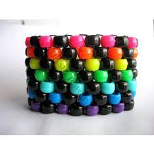 a stack of bracelets with different colored beads on each one and a cup next to it