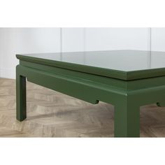 a green coffee table sitting on top of a hard wood floor