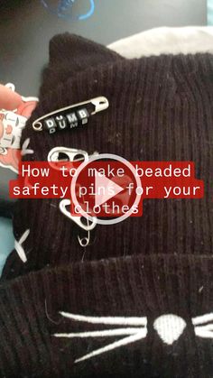 someone is holding onto a black cat hat with the caption how to make beaded safety pins for your clothes