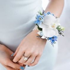 a close up of a person wearing a wedding ring and holding a flower in their hand