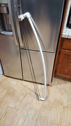 a stainless steel refrigerator in a kitchen with wood flooring