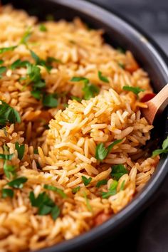 a pan filled with rice and garnished with parsley