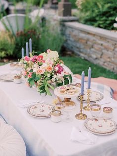 a table with plates and candles on it