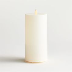 a white candle is lit on a white background