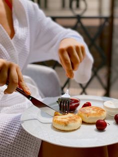 a person cutting food on top of a white plate