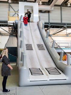 two people standing on top of a slide in a building