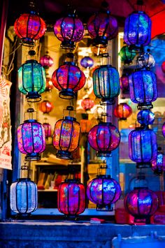 many colorful lanterns are hanging from the ceiling