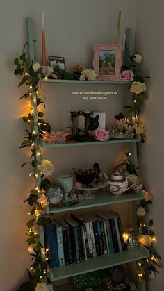 a shelf filled with lots of books covered in flowers and greenery next to a wall