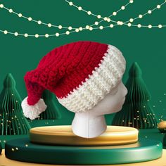 a red and white knitted hat sitting on top of a mannequin head