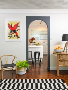 a living room filled with furniture and a painting on the wall above a wooden table