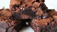 chocolate brownies stacked on top of each other in a white plate with one bite taken out