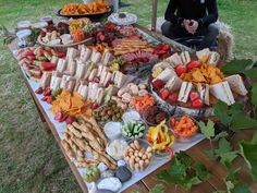 a man sitting in front of a table filled with different types of food on it