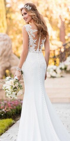 a woman in a white wedding dress holding flowers