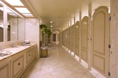 a long hallway with several sinks and mirrors