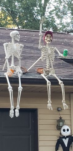 two skeletons hanging from the roof of a house