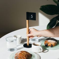 a table topped with pastries and drinks on top of a white table cloth covered in black numbers