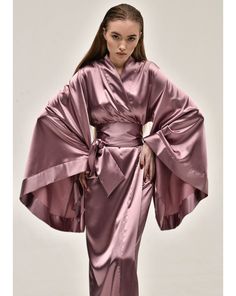 Evoking the polished sophistication of the geisha, the KAfemme long satin kimono is the epitome of elegance. Made of silk and satin blend in delicate lilac color the obi belt brings soft femininity to the silhouette. ✓ garment length - 147 cm/58'' ✓ wrap over style ✓ two sets of inside ties ✓ wide obi-tie is included Material Composition:  polyamide 60%, viscose 20%, polyester 10%, silk 7%, elastane 3% *CAN BE ORDERED IN 100% MULBERRY SILK* Model is 172 cm/67.6'' tall and wears size XS/S. Fancy Robe, Fancy Robes, Silk Robes, Luxury Robes, Maxi Kimono, Strapless Prom Dress, Silk Kimono Robe, Satin Kimono, Obi Belt