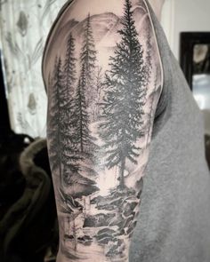 a man with a forest tattoo on his arm