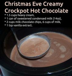 an image of a bowl of hot chocolate with a spoon in it and the words christmas eve creamy crockpot hot chocolate