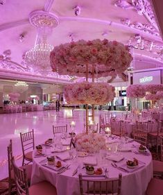 the tables are set up with pink flowers and centerpieces for an elegant wedding reception