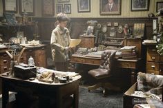 a young boy standing in an old fashioned office