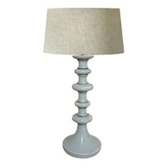 a blue lamp with a beige shade on it's side and a white linen shade on the top