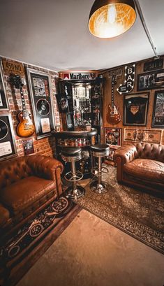 a living room filled with lots of furniture and pictures on the wall next to a bar