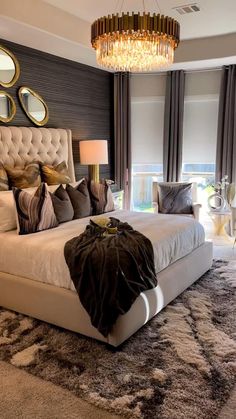 a bed room with a neatly made bed and a chandelier