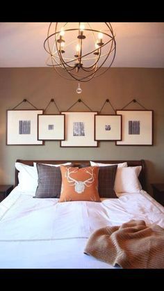 a bed with pillows and pictures hanging on the wall