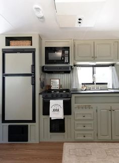 a kitchen with gray cabinets and black appliances