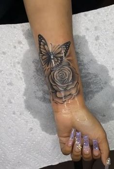 a woman's foot with a butterfly and rose tattoo on the left side of her arm