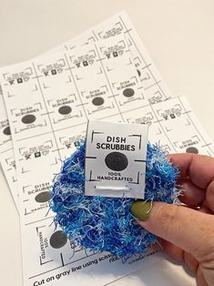 a hand holding a blue and white object on top of a sheet of paper