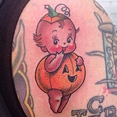 a girl with a pumpkin tattoo on her arm