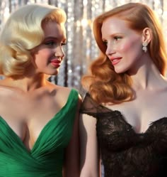 two women in evening gowns standing next to each other, one with blonde hair and the other wearing green