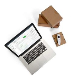 an open laptop computer sitting on top of a desk next to a mouse and box