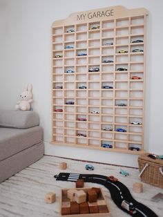 a toy car garage is in the corner of a room with toys on the floor