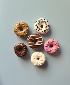 six donuts are arranged on a blue surface