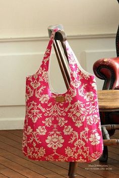 a pink and white bag sitting on top of a wooden table next to a chair