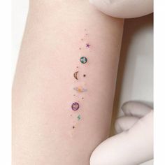 a woman's arm with planets and stars on it