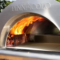 an outdoor pizza oven with flames coming out of it's sides and the words pina cola written in spanish