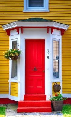 a red front door on a yellow house