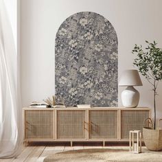 a living room with an arched window and wicker sideboard in front of it