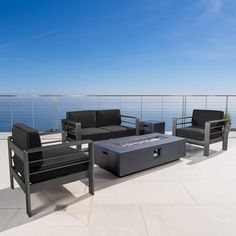 a patio with black furniture and an ocean view in the backgroung area