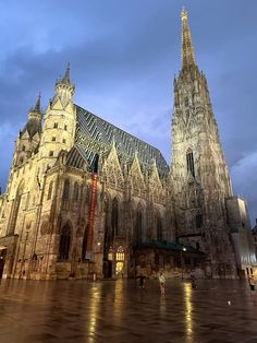 the large cathedral has many spires on it's sides and is lit up at night