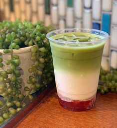 a green drink sitting on top of a wooden table