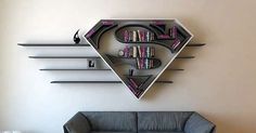 a living room with a couch, book shelf and wall mounted bookshelf in the shape of a triangle