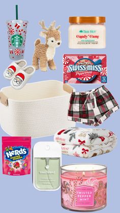 the contents of a christmas gift basket are arranged on a blue background, including candles, cookies, and candy