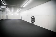 an empty parking garage with white walls and black flooring on the wall is lit by recessed lights