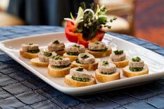 small appetizers are arranged on a white platter with blue cloth tablecloth